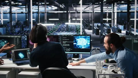 Data center team of engineers tries to fix critical error warning while using AI Stock Footage 313567236