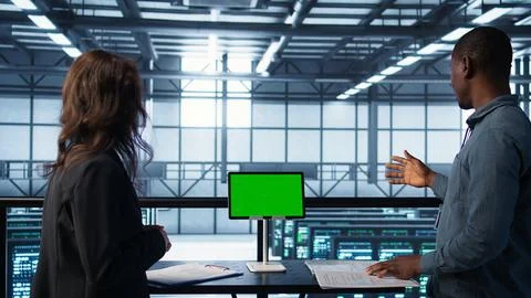 Data center team using mockup green screen tablet, reviewing paperwork Foto stock