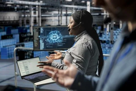 Data center tech support admin using headset mic interpreting AI generated logs 스톡 사진