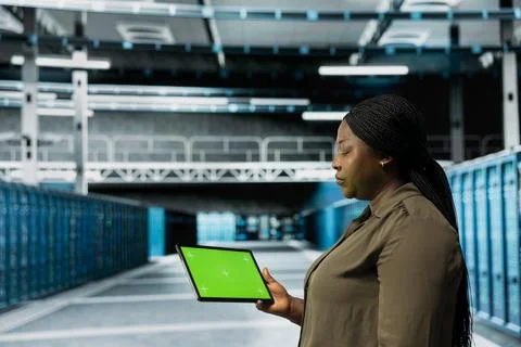 Data center technician conducts tests on hardware using isolated screen tablet Stock Photos