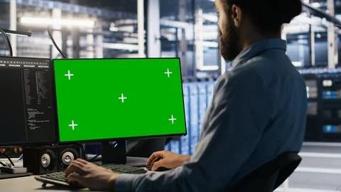 Data center technician doing software updates using green screen mockup computer Foto stock
