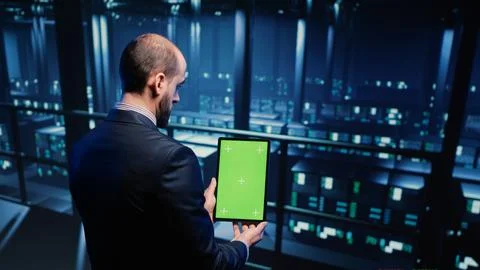 Data center technician holding tablet with green screen Foto stock