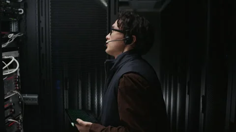 Data Center Technician Inspecting Server Ports with Tablet Stock Footage 330541183