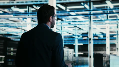 Data center technician managing blue wireframe mesh gear Stock Footage 329652142
