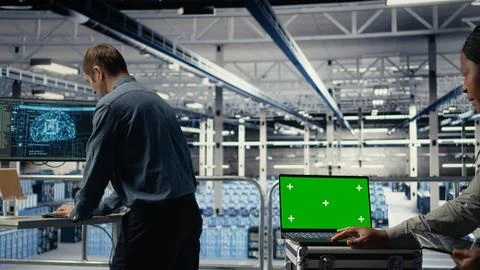 Data center technician monitors deep learning process with green screen laptop Stock Photos
