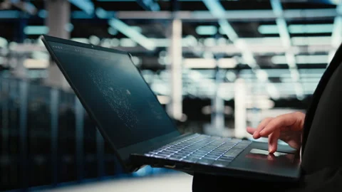 Data center technician using AI LLM assistant on laptop to troubleshoot issues Stock Footage 329324318
