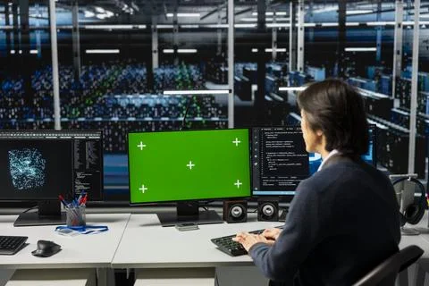 Data center technician using chroma key computer, working on AI databases Stock Photos