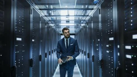 Data Center Technician Walking Through Server Rack Corridor Visually Inspecti 스톡 사진