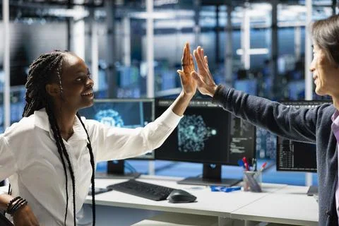 Data center technicians doing high five, happy after no issues detected Stock Photos