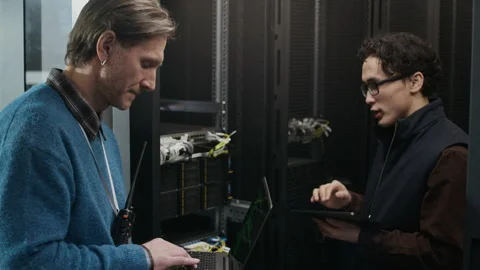 Data Center Technicians Inspecting Network Cables in Server Infrastructure Stock Footage 330543054