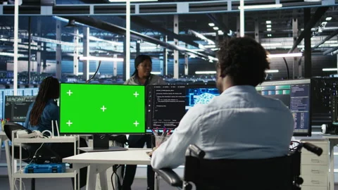 Data center worker with paraplegia using node trees on green screen PC Stock Footage 307038941