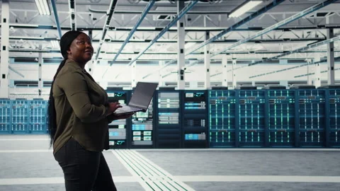 Data center worker using laptop to manage software updates for system stability Video stock 317125511