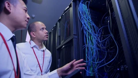 Data Centre with rows of servers and technicians Stock Footage 75344312