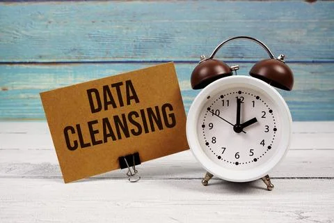 Data Cleansing text written on paper card with alarm clock on wooden backgrou Stock Photos