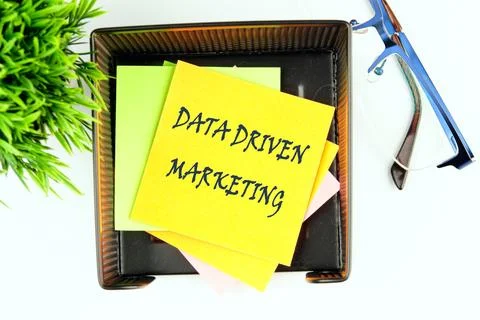 DATA DRIVEN MARKETING text on a yellow sticker in a stand on a white backgr.. Stock Photos