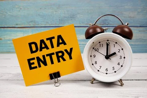 Data Entry text written on paper card with alarm clock on wooden background Stock Photos