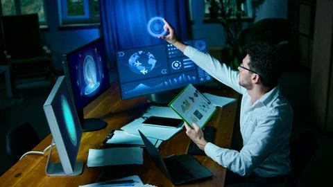 Data expert holding charts and analyzing holographic financial projections Stock Photos