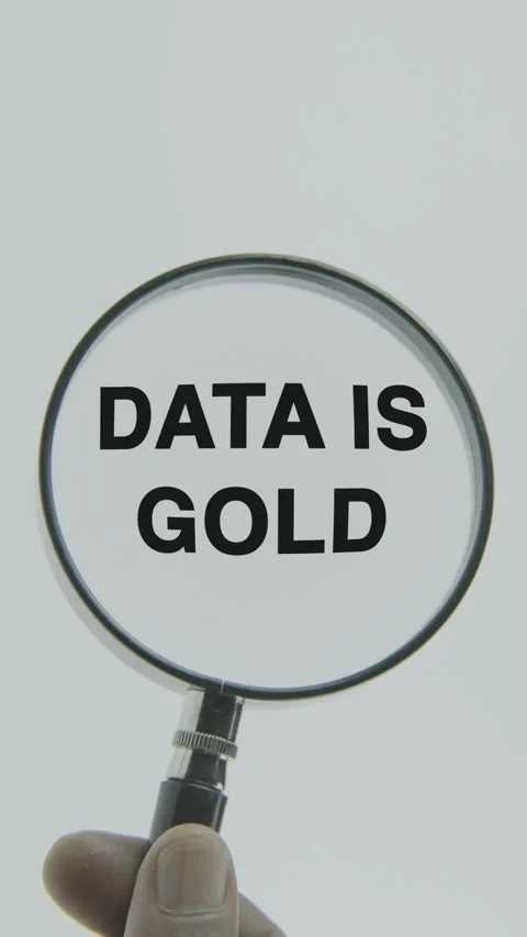 Data is Gold text or word highlighted by a magnifying glass in a hand Stock Footage 303429456