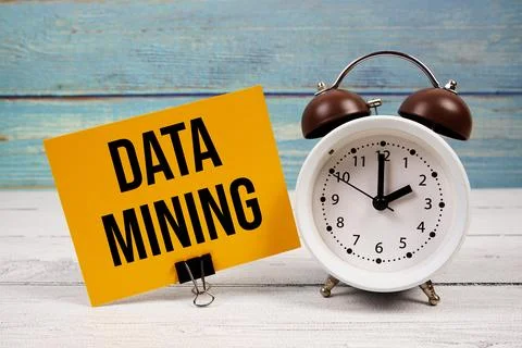 Data Mining text written on paper card with alarm clock on wooden background Stock Photos