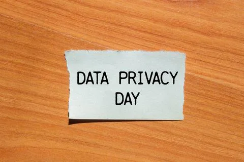 Data privacy day message written on ripped torn paper piece with wooden bac.. Stock Photos