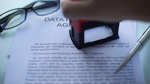 Data processing agreement confidential, hand stamping seal on business document Stock Footage 100695726