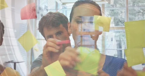 Data processing over caucasian male and female office colleagues sticking memo Stock Footage 327645458