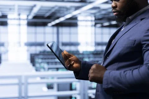 Data researcher using tablet in high tech data center, ensuring cybersecurity Stock Photos
