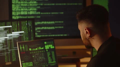 A data scientist analyzes data from monitors that display program code. A male Stock Footage 236773499