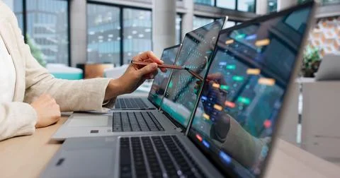Data Scientist Studies Deep Learning Models On Laptop In Busy Office. Stock Photos