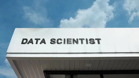 Data Scientist word sign displayed on building with blue sky background Stock Footage 318608893