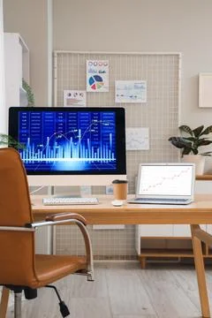 Data scientists workplace with computer and diagrams in office Stock Photos