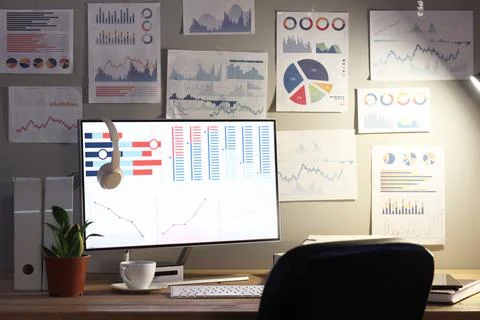 Data scientist's workplace with computer and diagrams in dark office 写真素材