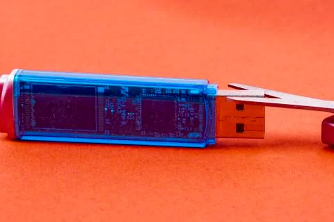 Data stick with scissors on red background Stock Photos