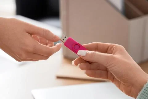 Data transfer and information sharing with pink USB flash drive between two p Stock Photos