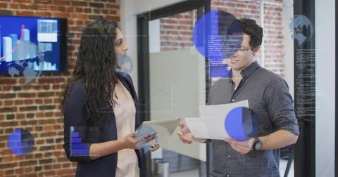 Data updating, colleagues holding tablet and papers while charts overlaying Stock Photos