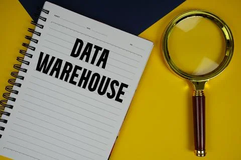 Data Warehouse text with magnifying glass on yellow background Stock Photos
