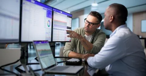 Database Administrator And Developer Collaborate Reviewing SQL Queries On Lap Stock-Fotos