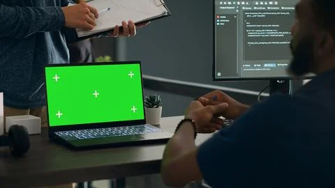Database admins analyzing source code and greenscreen display on computer Stock Photos