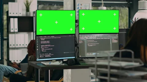Database developer analyzing greenscreen display on multiple screens Stock Footage 227616373