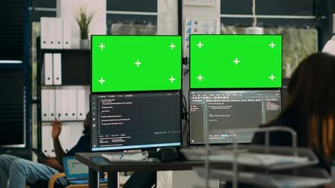 Database developer analyzing greenscreen display on multiple screens Stock Photos
