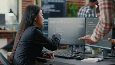 Database developer pointing pencil at computer screen with software compiling Stock Footage 168236022