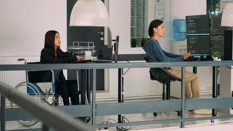 Database programer with physical disability writing code on computer screen 스톡 사진