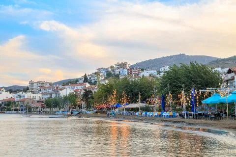 Datca beach with lantern lights on trees and reflection on sea during dusk in Stock Photos