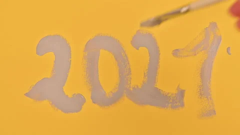 Date 2021, painted with a brush in gray paints on a yellow background. Stock Footage 145226569