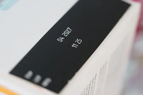Date and time printed on a white medicine box in a close-up view Stock Photos
