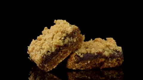 Date Dessert Squares Rotating on Dark Reflective Surface Stock Footage 330517480