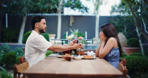 Date, engagement ring and marry me with couple in restaurant together for Stock Footage 321126441