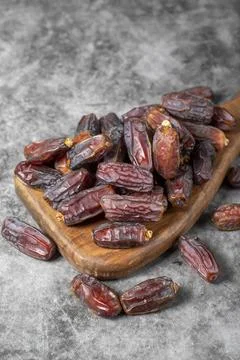 Date fruit on a dark background. Organic pile of medjoul dates on a wood serv Foto stock