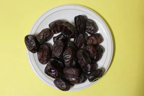 Date fruit on a plate yellow background Ramadan fruits Stock Photos