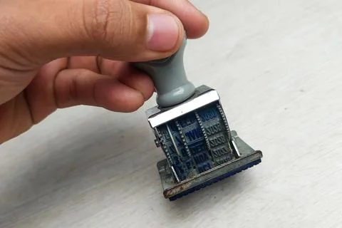 Date Stamp in Hand on White Table 스톡 사진